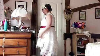 In an outfit with a long white lace dress styled like a wedding dress for an evening.
