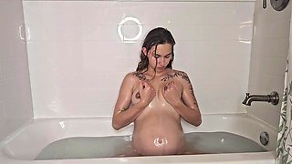 Pregnant hottie enjoys a relaxing bath with her perfect natural tits on display