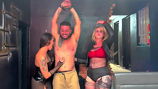 Two beautiful dominatrixes give their submissive a beating.