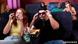 She grabs his crotch from a home-cinema recliner while wearing a green tee